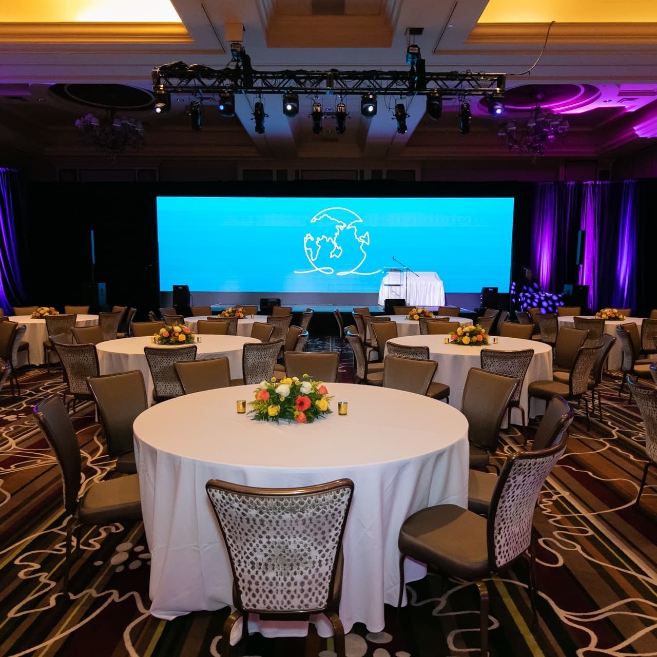 General session ballroom set in rounds with stage and screen