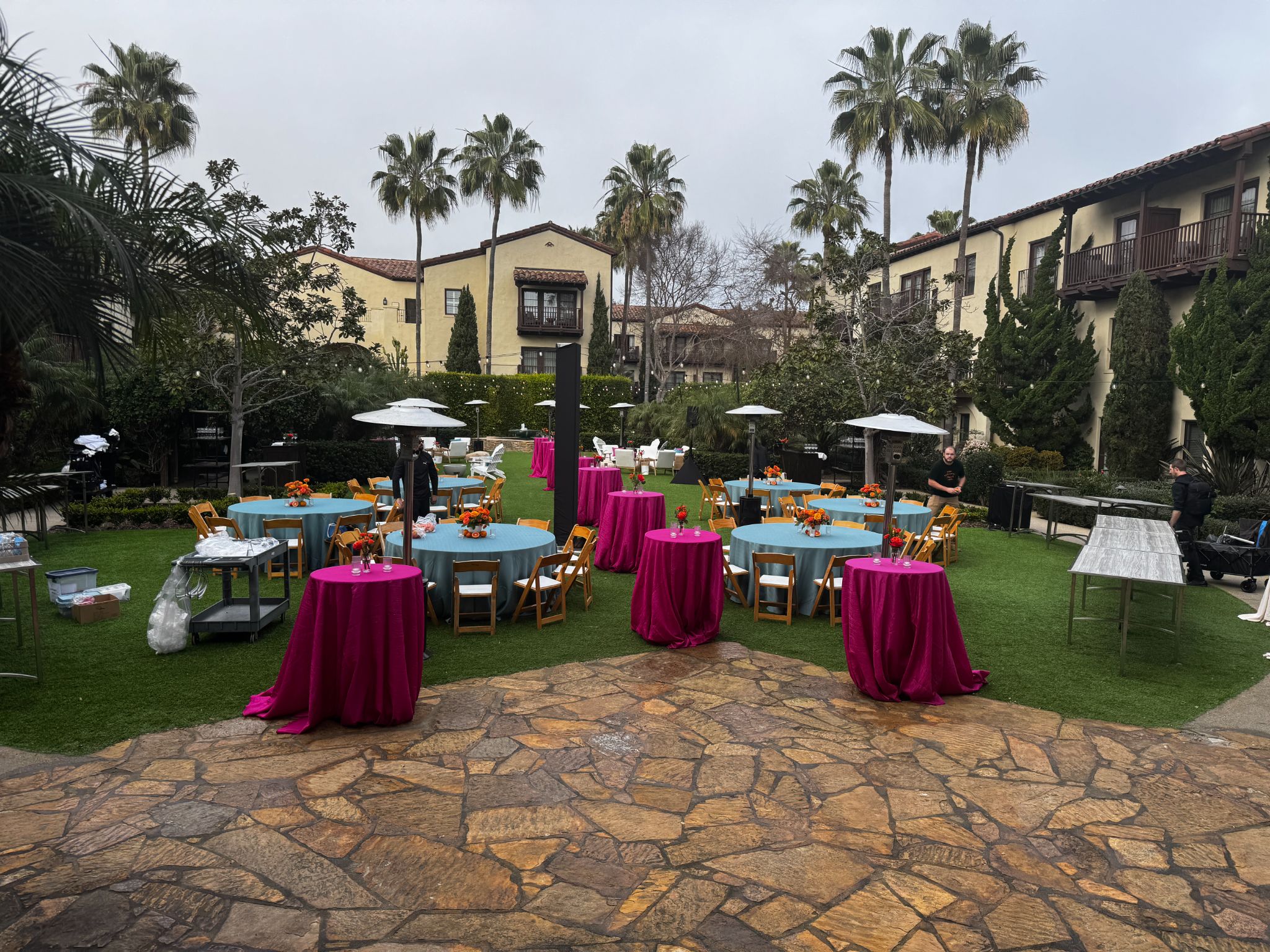 Outdoor courtyard reception with magenta linens and heaters